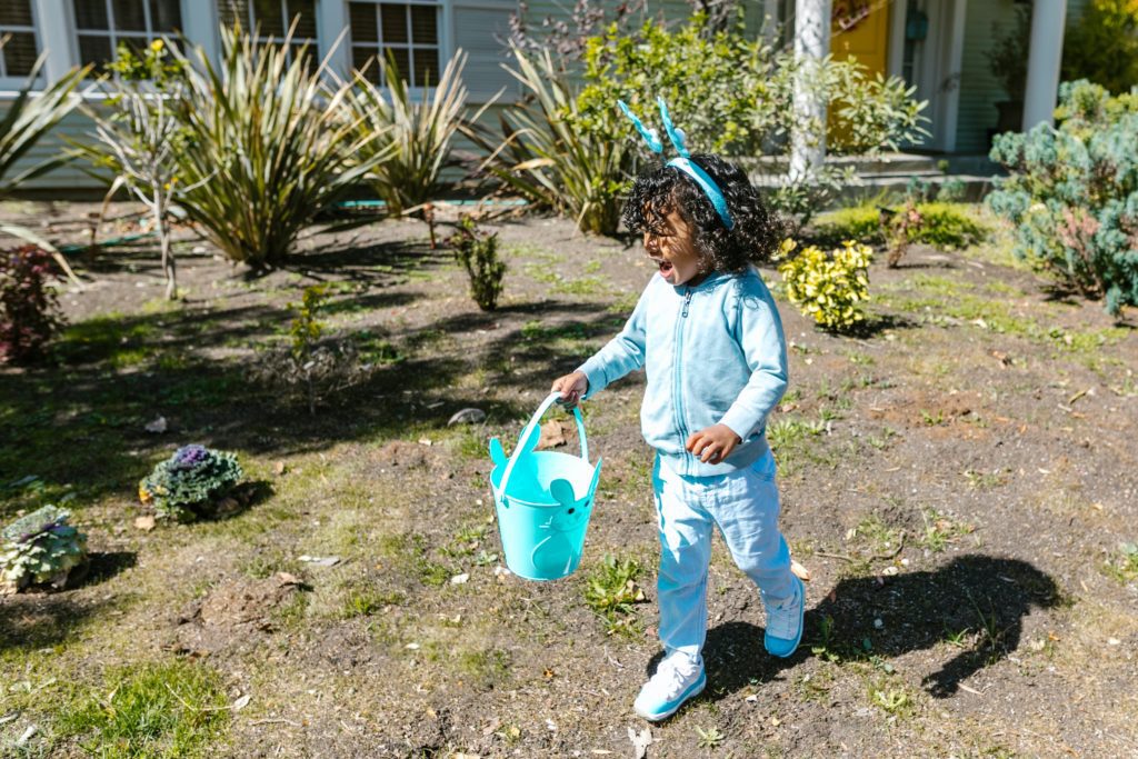 Little girl hunting for easter eggs as part of kids easter games